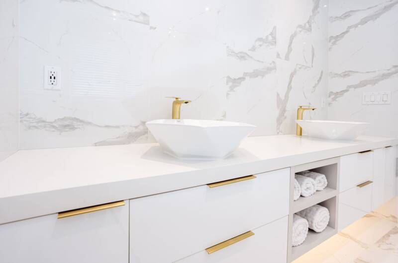 bathroom sinks with a golden details - white marble walls
