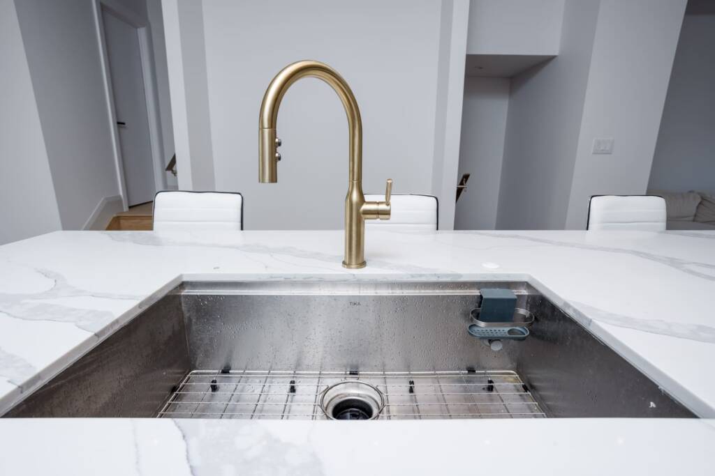 kitchen faucets on top of white countertop